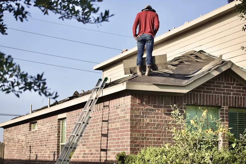 Professional roofer working on a residential roof in Nederland